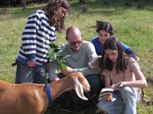 After all the work is done, Jeff and the kids try to identify a tree with berries. Honey may look interested in the field guide, but what she really wants is to eat those leaves!